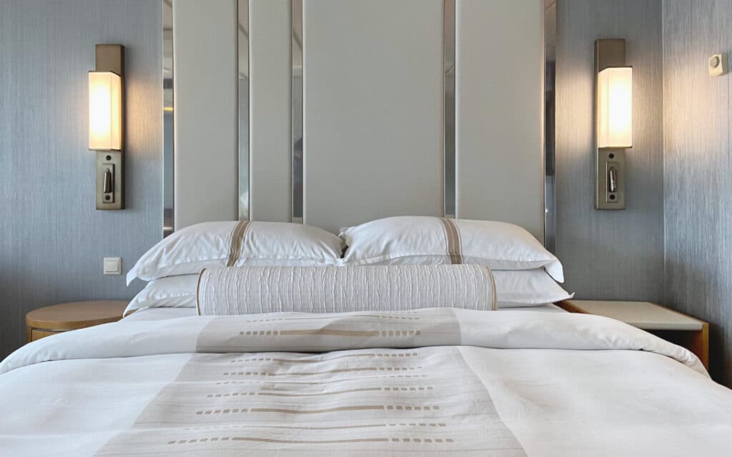 A queen bed setup in a Veranda Stateroom on Azamara Quest.