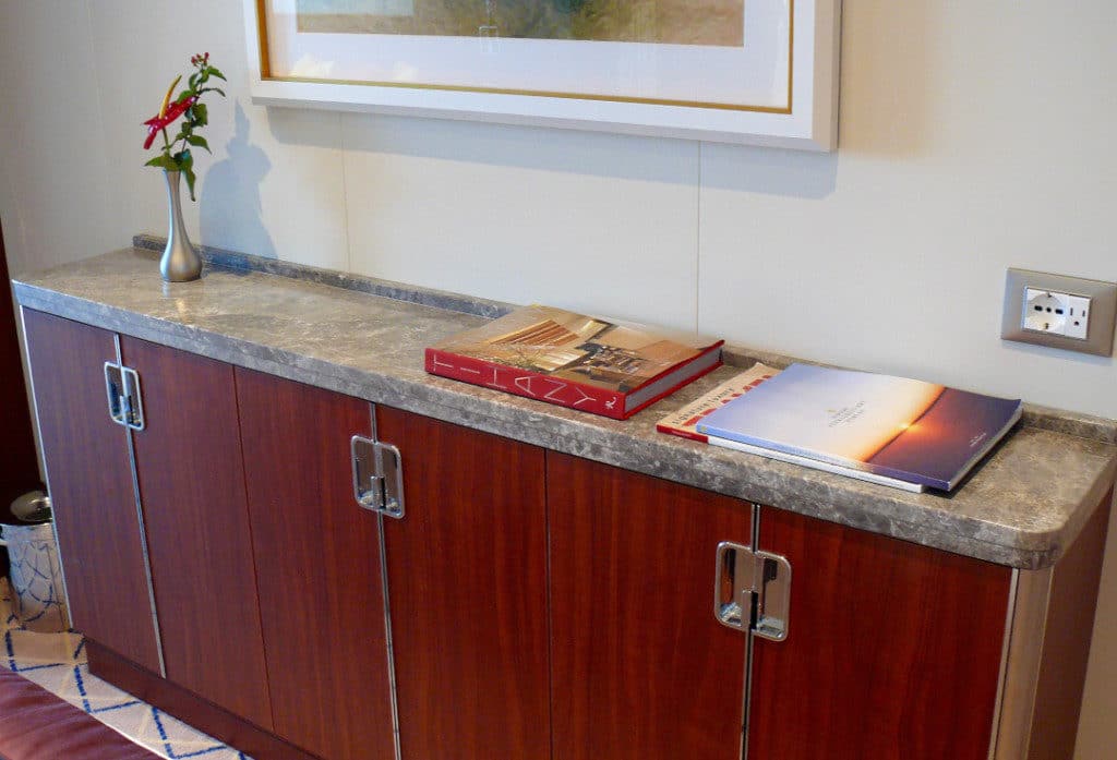 A marble topped cabinet at the foot of the bed offers ample storage.