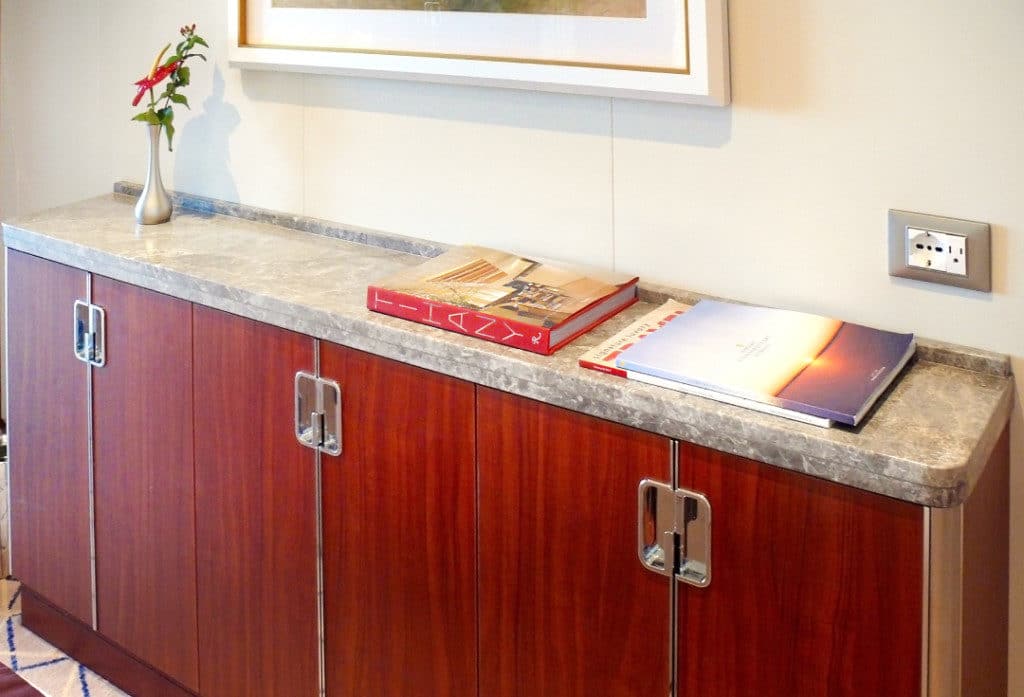 A marble topped cabinet at the foot of the bed offers ample storage.