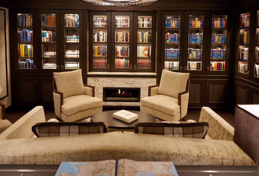 The new Seven Seas Mariner library with dark-wood bookshelves.
