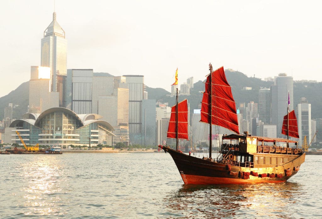 Traditional junks sail past skyscrapers in Hong Kong.