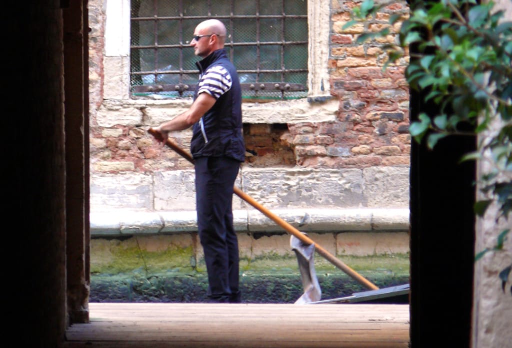 A gondolier rows his boat in Venice, Italy.