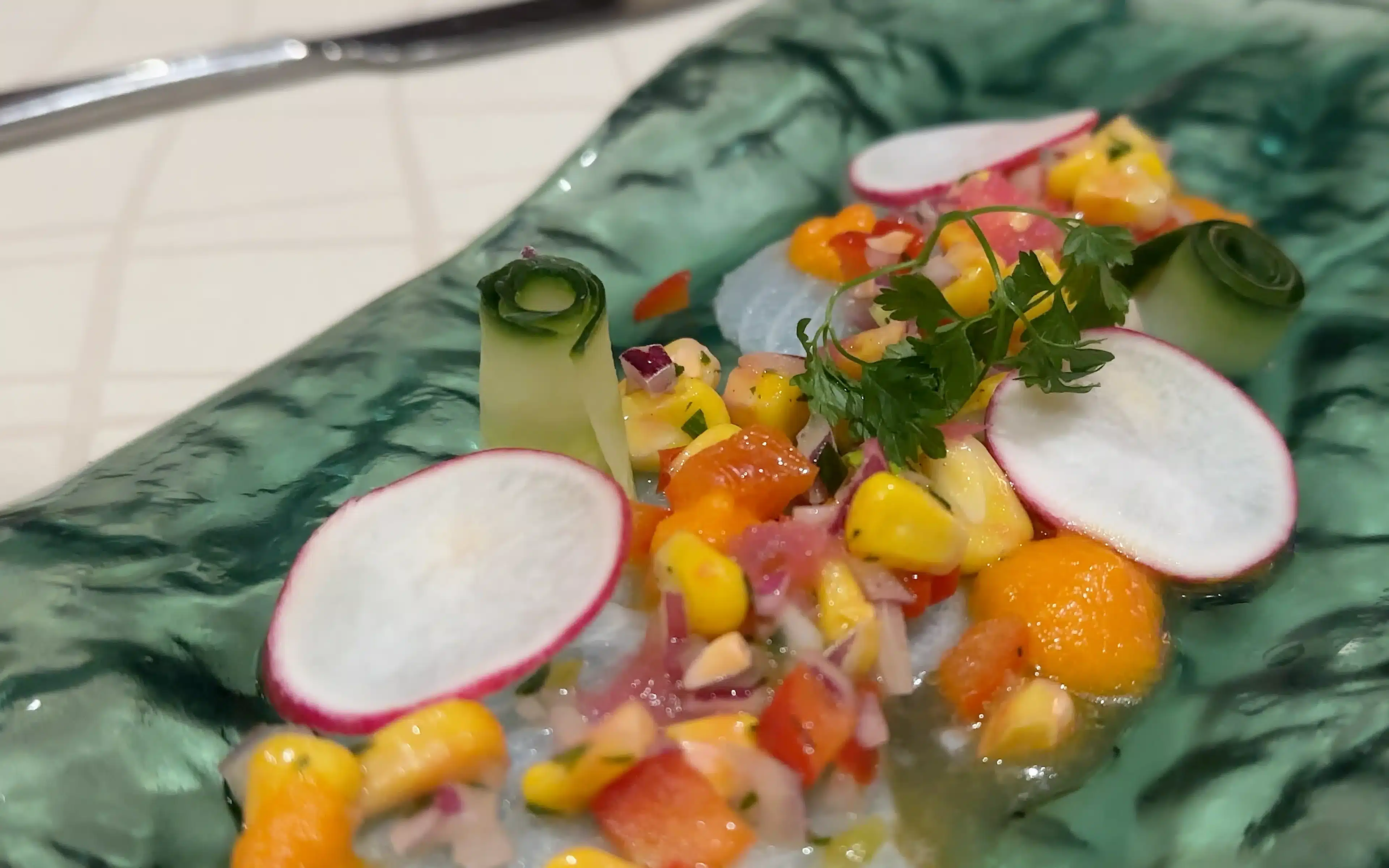 Thinly Sliced Seabass, Red Onion, Coriander, 'Leche de Tigre' Marinade, Habanero Chillies, Lime, Garlic, Corn, and Cucumber.