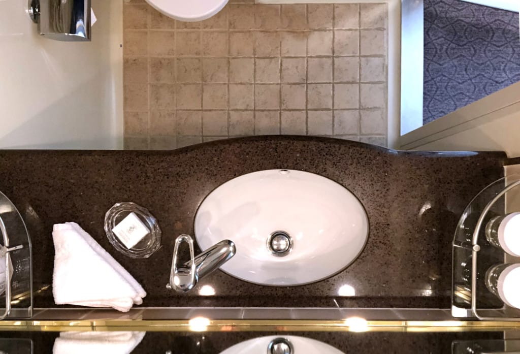 An overhead view of the bathroom vanity in a Balcony room.
