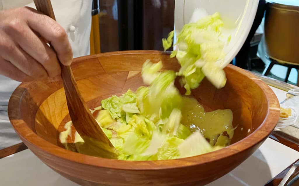 A caesar salad being prepared by a chef on Seabourn Quest.