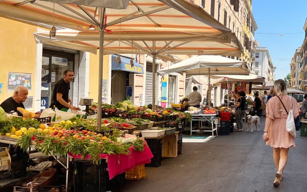 A woman walks through a market in Rome, Italy.