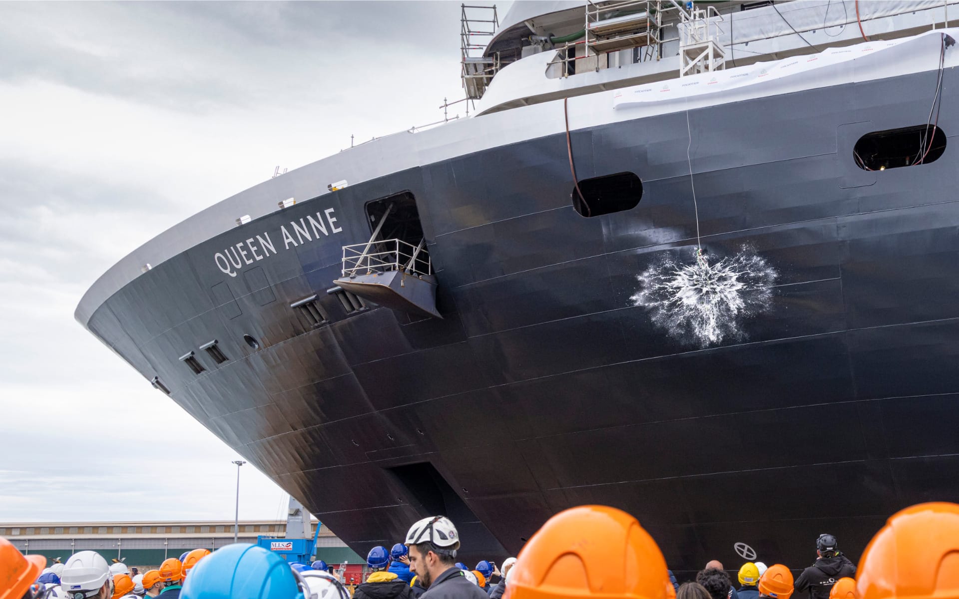 A bottle of Prosecco smashes over the hull of the Queen Anne cruise ship during the float out ceremony.