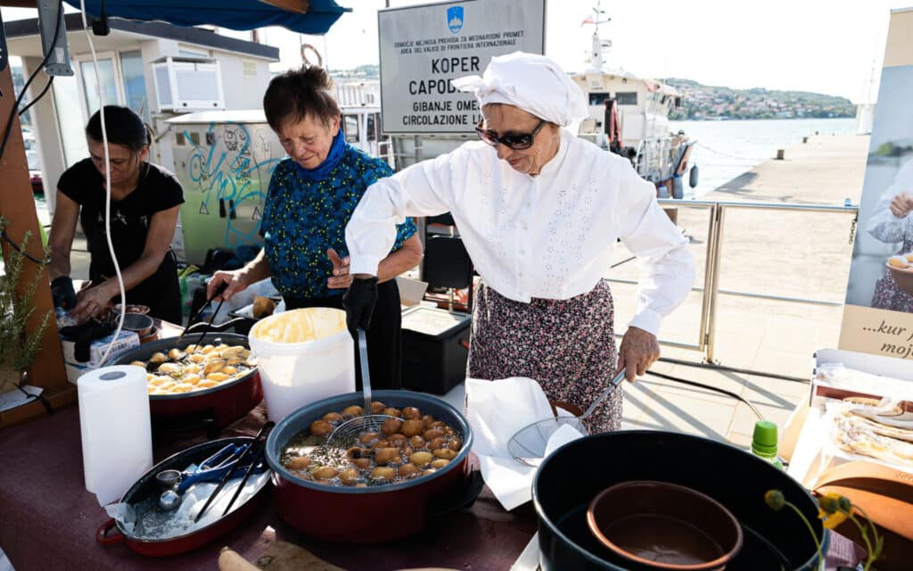 A woman cooks food at the Gourmet Festival.