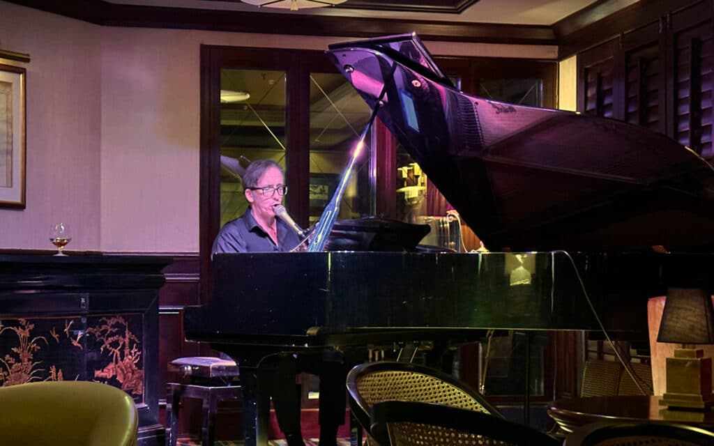 A pianist sings in the Avenue Salon on Crystal Sympony.
