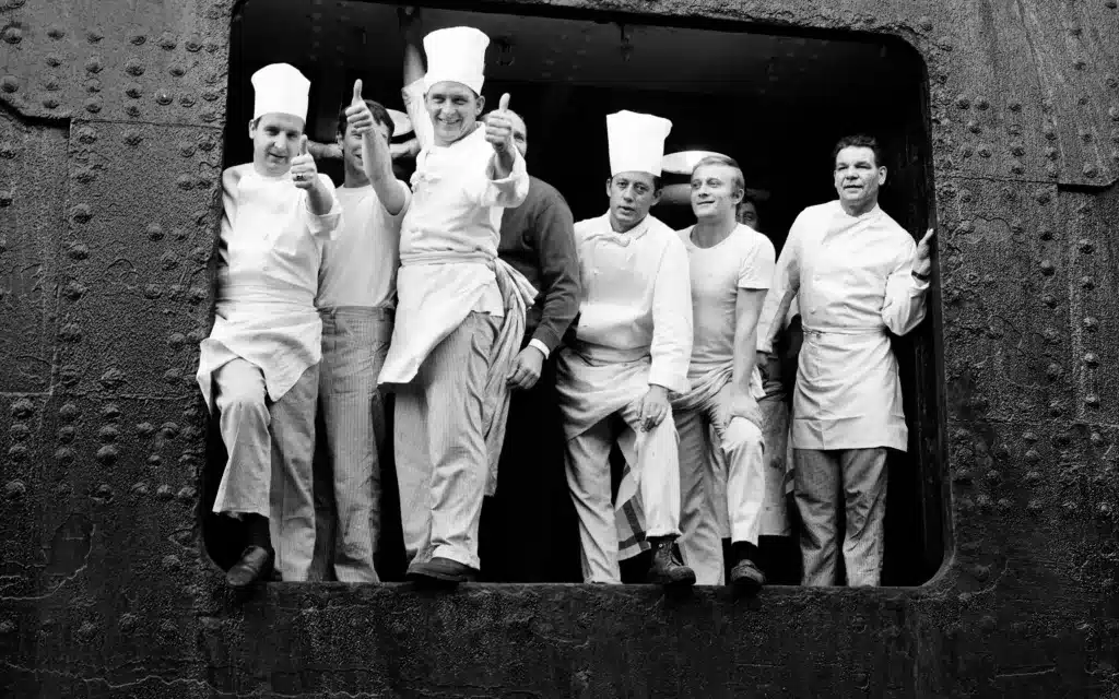 Galley staff gather at an open portal aboard a Cunard liners.