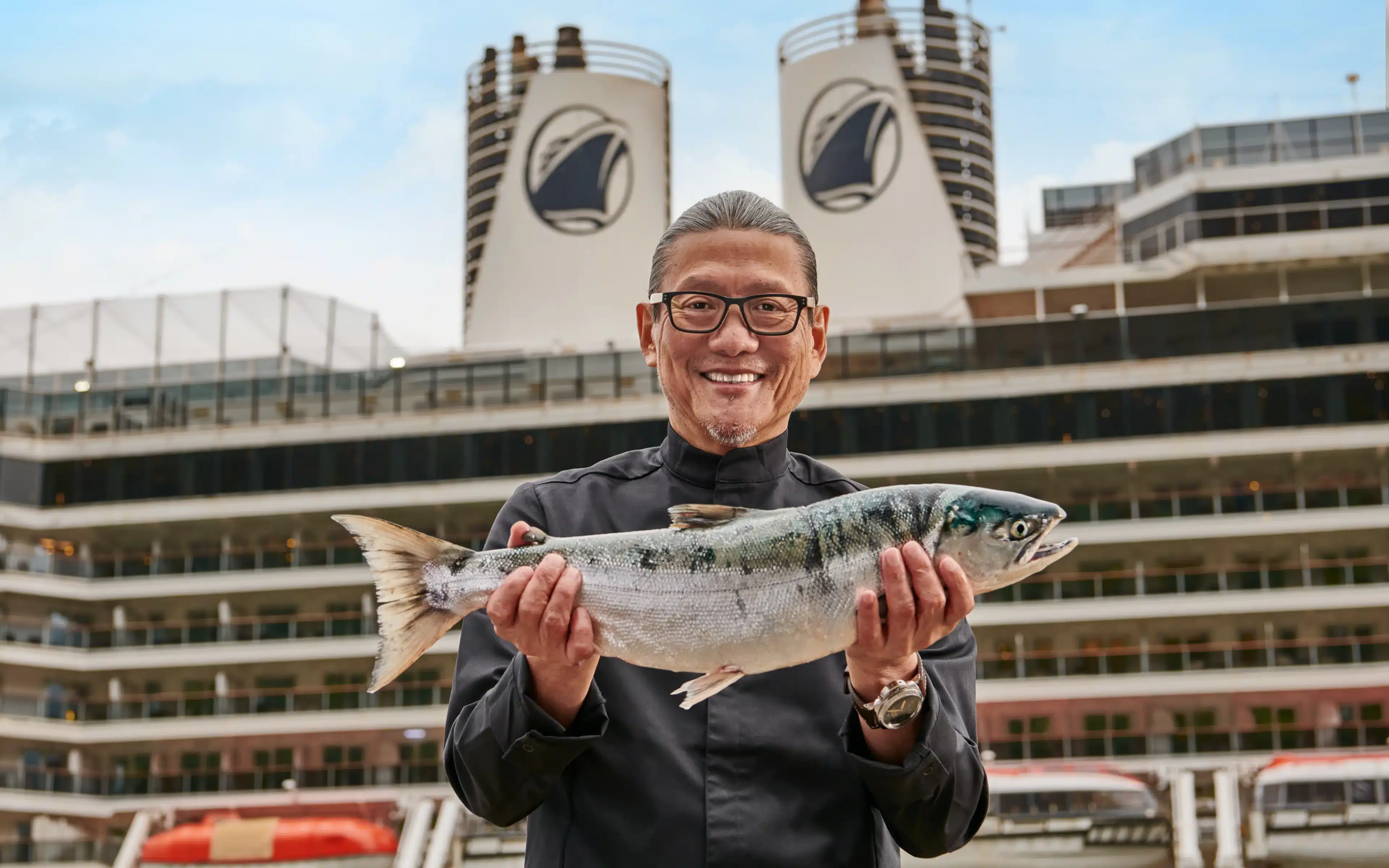 Chef Masaharu Morimoto holding a salmon fish.