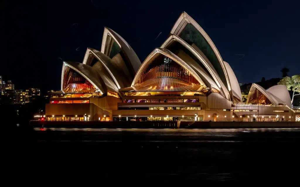 The SYdney Opera House lit up at night.