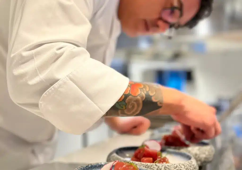 Chef Gustavo Sugay prepares food in a restaurant kitchen.