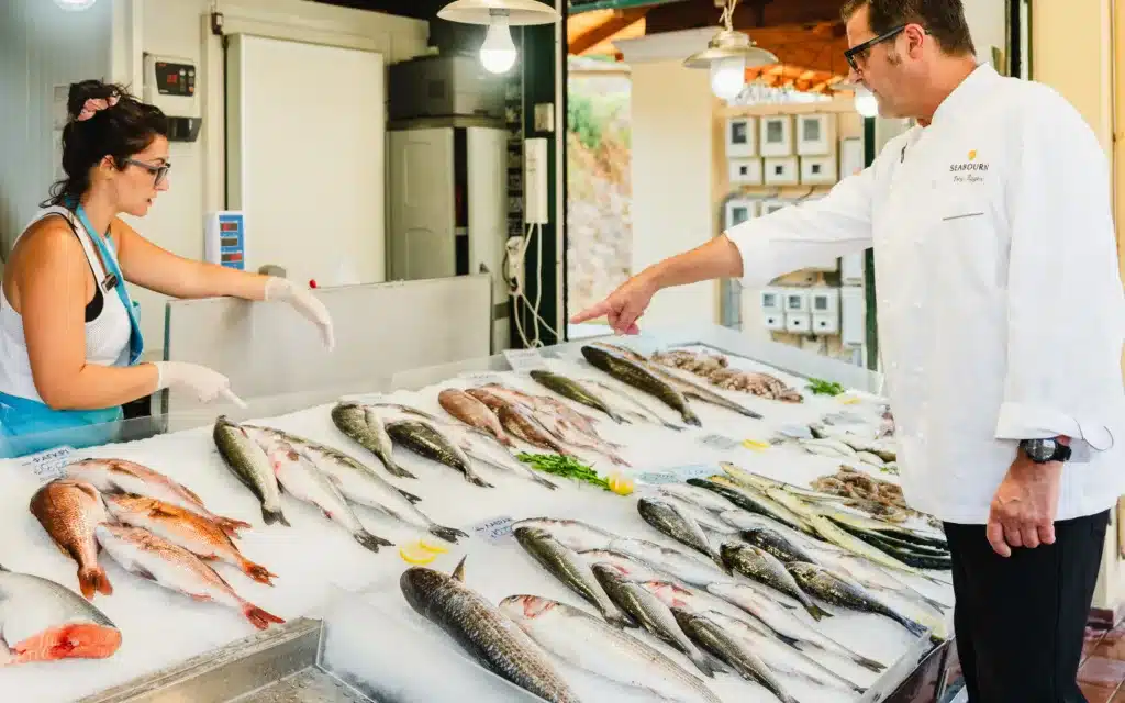 Seabourn chef Tony Egger purchasing seafood in a market.