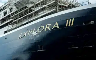Champagne breaks over the bow of the Explora III cruise ship.