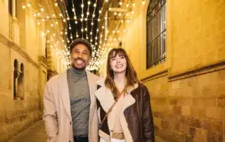 Happy couple shopping during a festive christmas evening under lights.