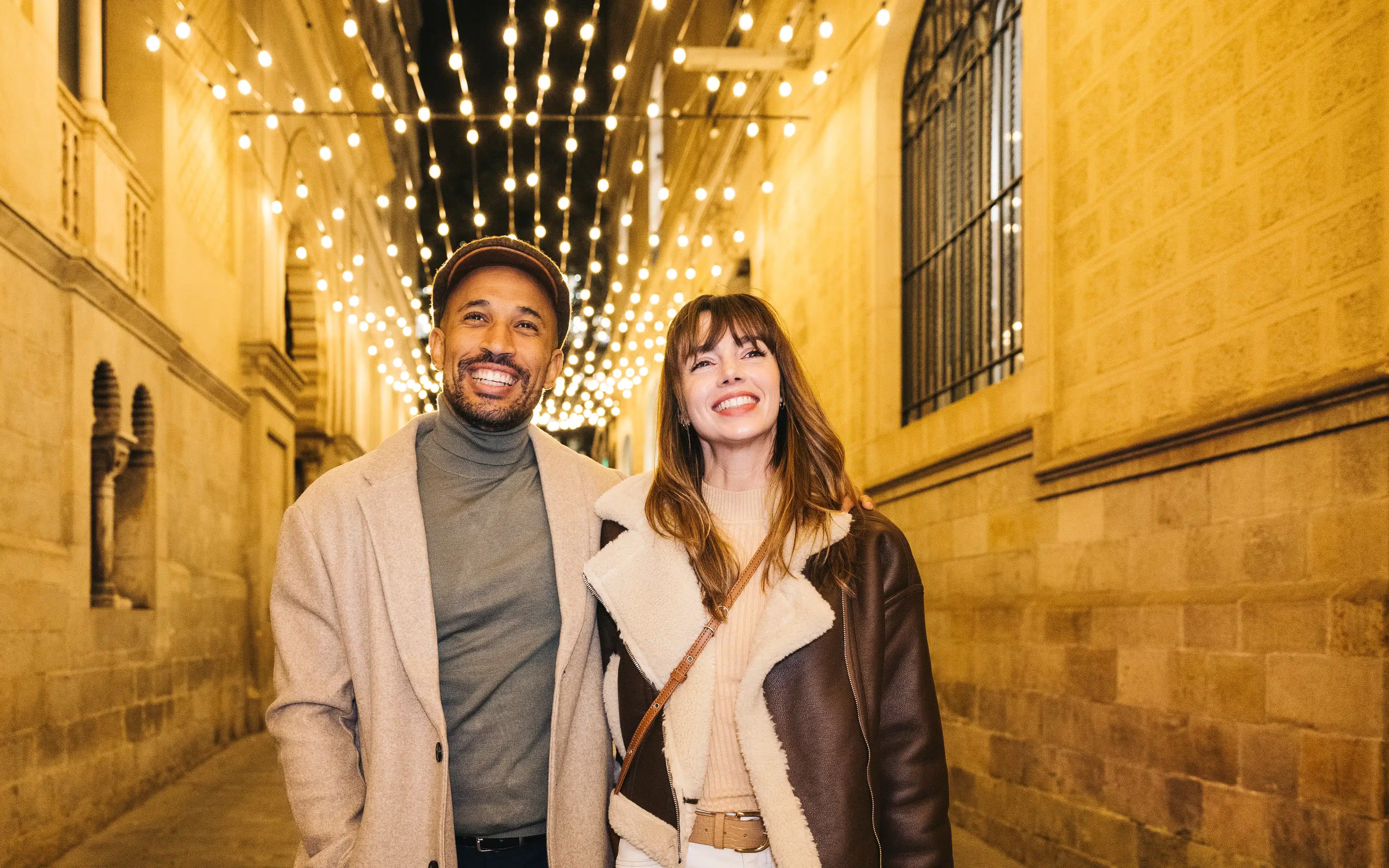 Happy couple shopping during a festive christmas evening under lights.