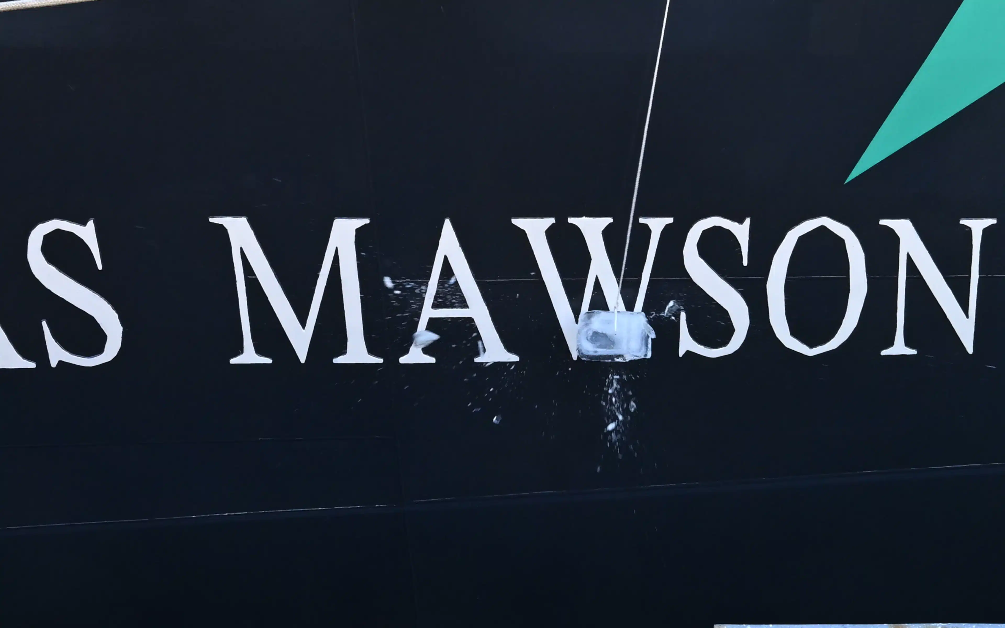 Douglas Mawson is christened with a block of ice smashed against the hull.