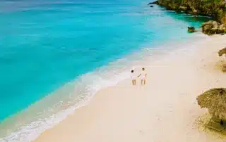 A couple walking on Playa Kalki Beach on the Caribbean island of Curacao.