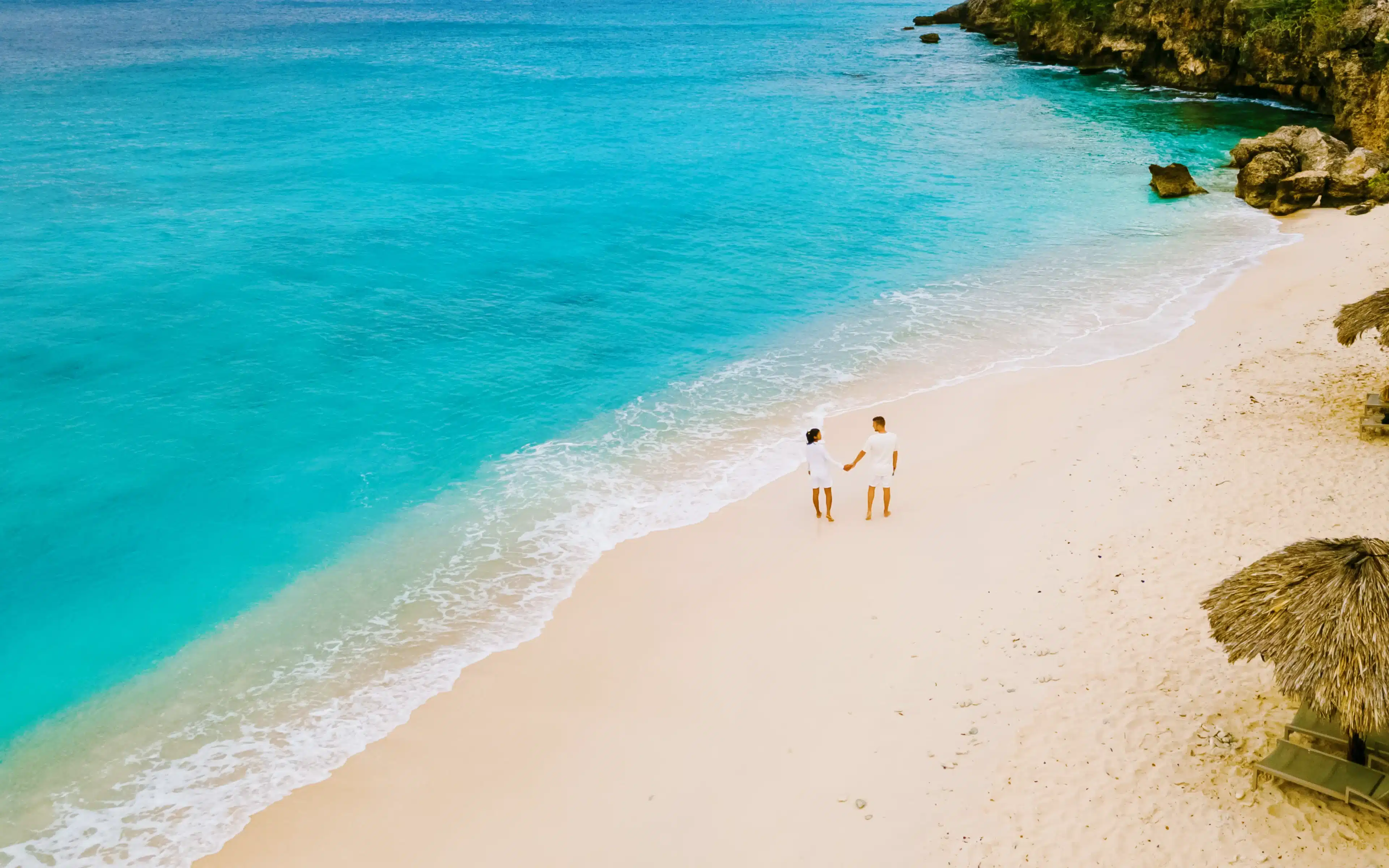 A couple walking on Playa Kalki Beach on the Caribbean island of Curacao.