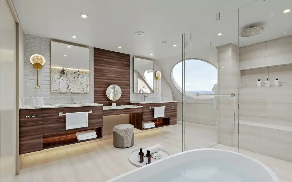 Oceania Suite bathroom with large porthole-style window rendering aboard Oceania Sonata.
