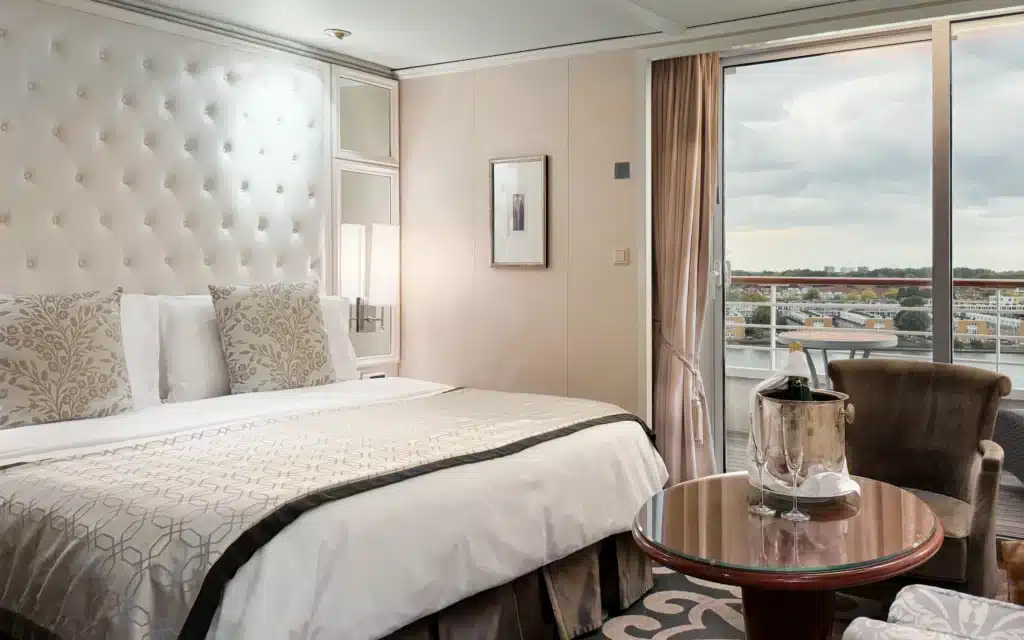 A view of the bedroom in an Aquamarine Suite on Crystal Serenity.
