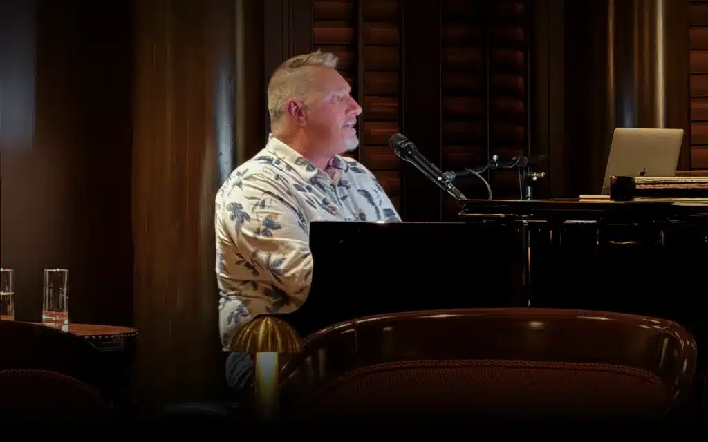 A male singer at the piano in the Avenue Saloon on Crystal Serenity.