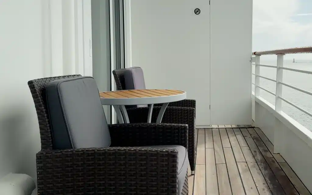 Outdoor furniture adorns a spacious teak veranda.