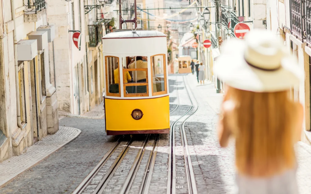 Woman in Lisbon with yellow cable car.