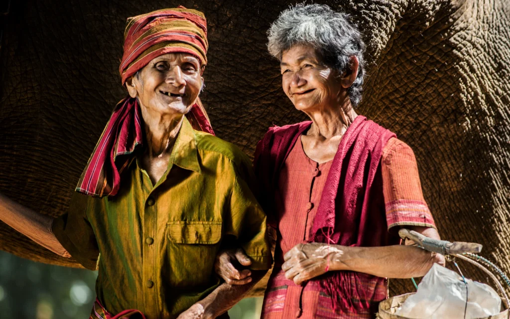 Elderly couple in Thailand wearing brightly coloured traditional clothing.