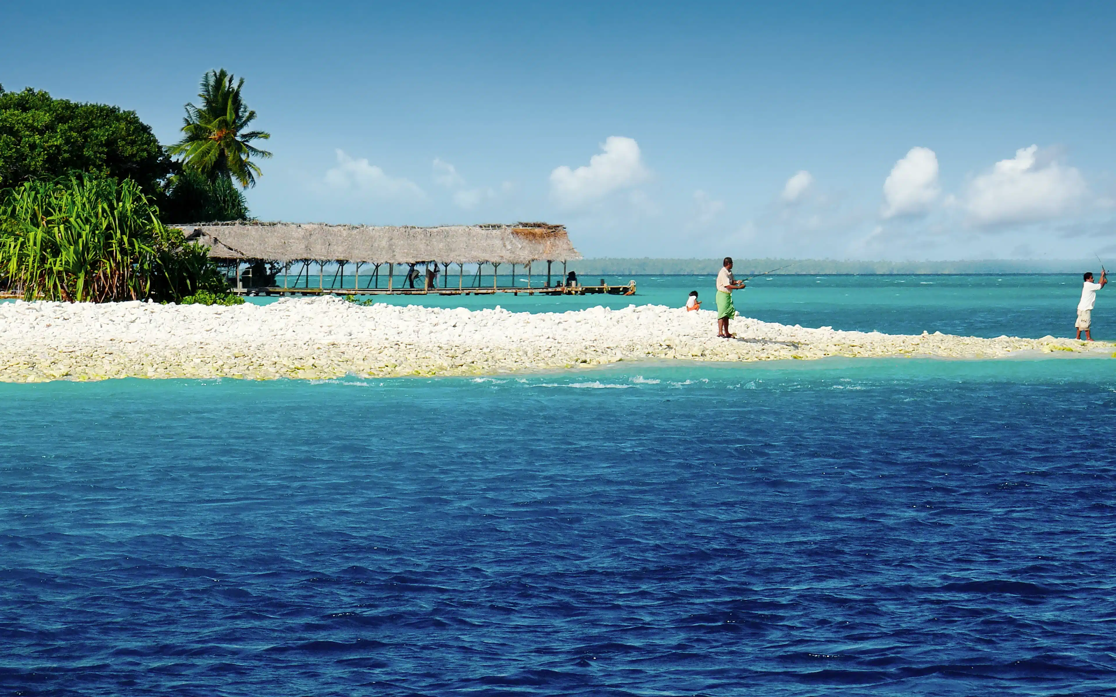 Local fishermen cast their lines into impossibly blue waters on a beach in French Polynesia.