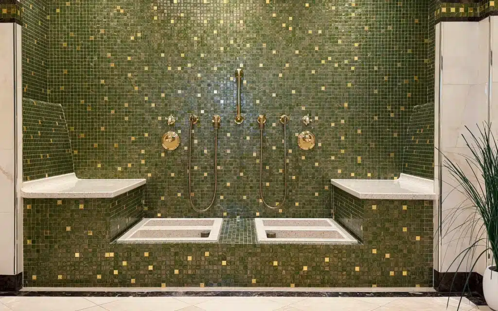 Sea Cloud Spirit spa foot bath area with symmetrical green and gold mosaic tiled walls, twin foot bath basins and gold shower fittings