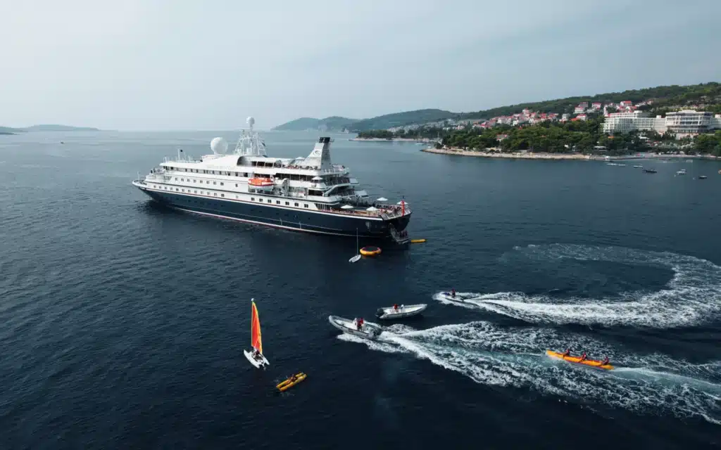 Aerial view of a SeaDream vessel anchored off Hvar, Croatia, with kayaks, a RIB tender and a sailing dinghy active in the surrounding water