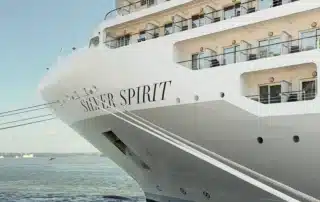 The bow of Silversea's Silver Spirit cruise ship moored in harbor under a clear blue sky