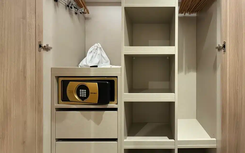 World Voyager Veranda and Horizon Suite wardrobe with dual hanging rails, open shelving, built-in drawers, and a gold digital in-room safe