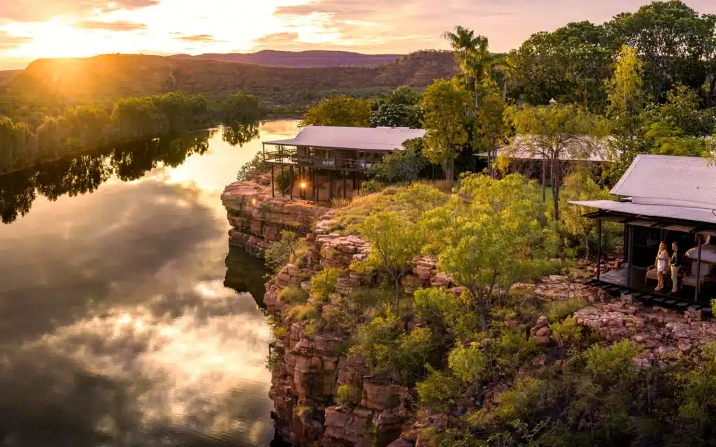 Cliffside lodge overlooking a river at golden hour