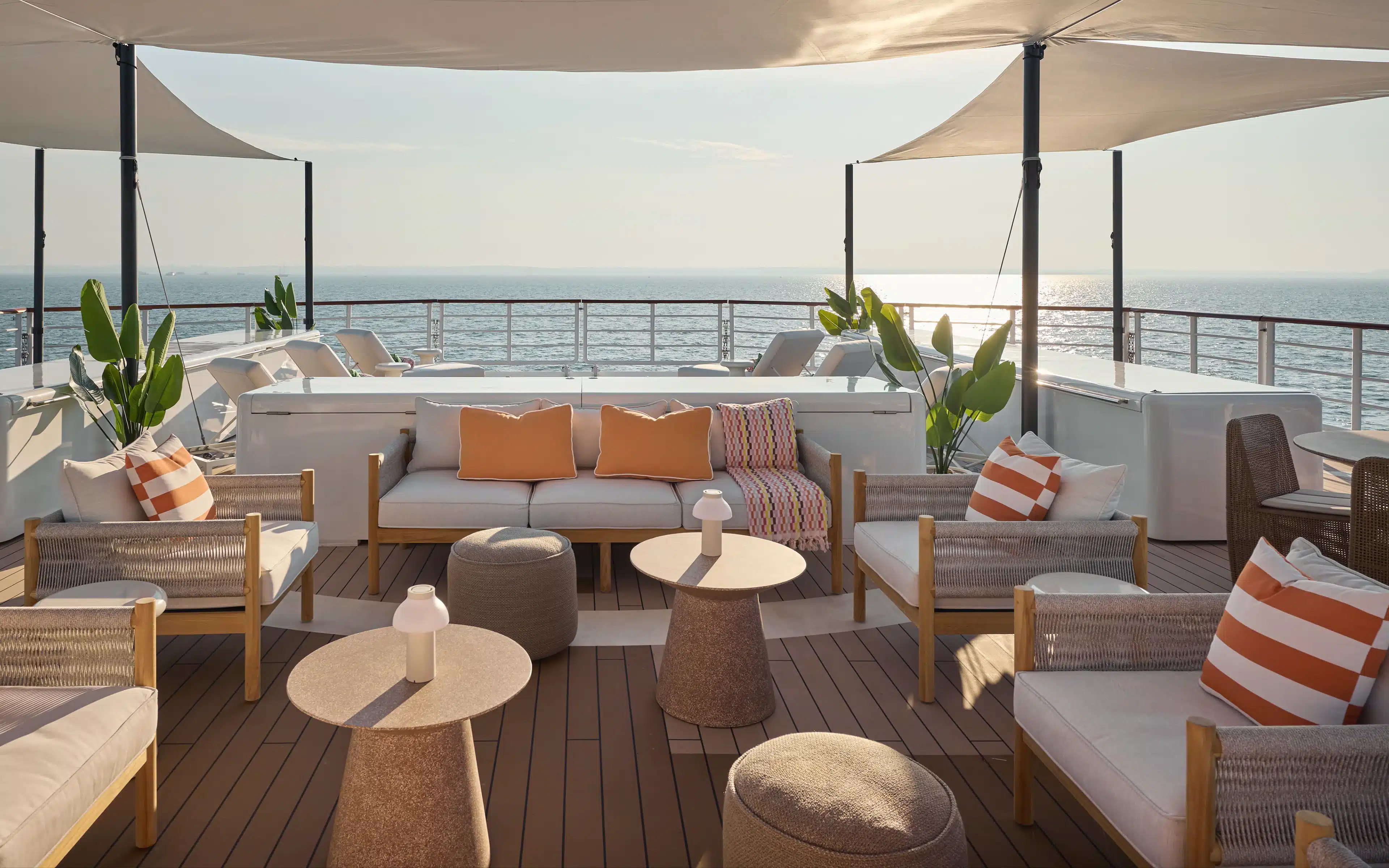 Shaded sundeck lounge with ocean view at sunset