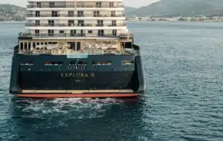 Explora III cruise ship stern view near coastline