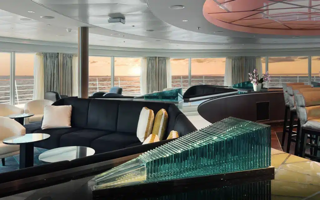Ship lounge with curved sofa and sunset ocean view