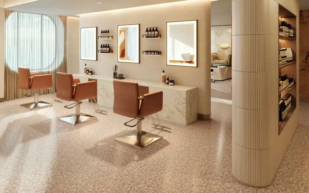 Salon chairs face illuminated mirrors on a terrazzo floor