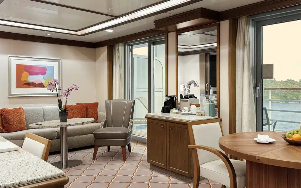 Silversea suite living and dining area with orchids, fruit bowl, and balcony view